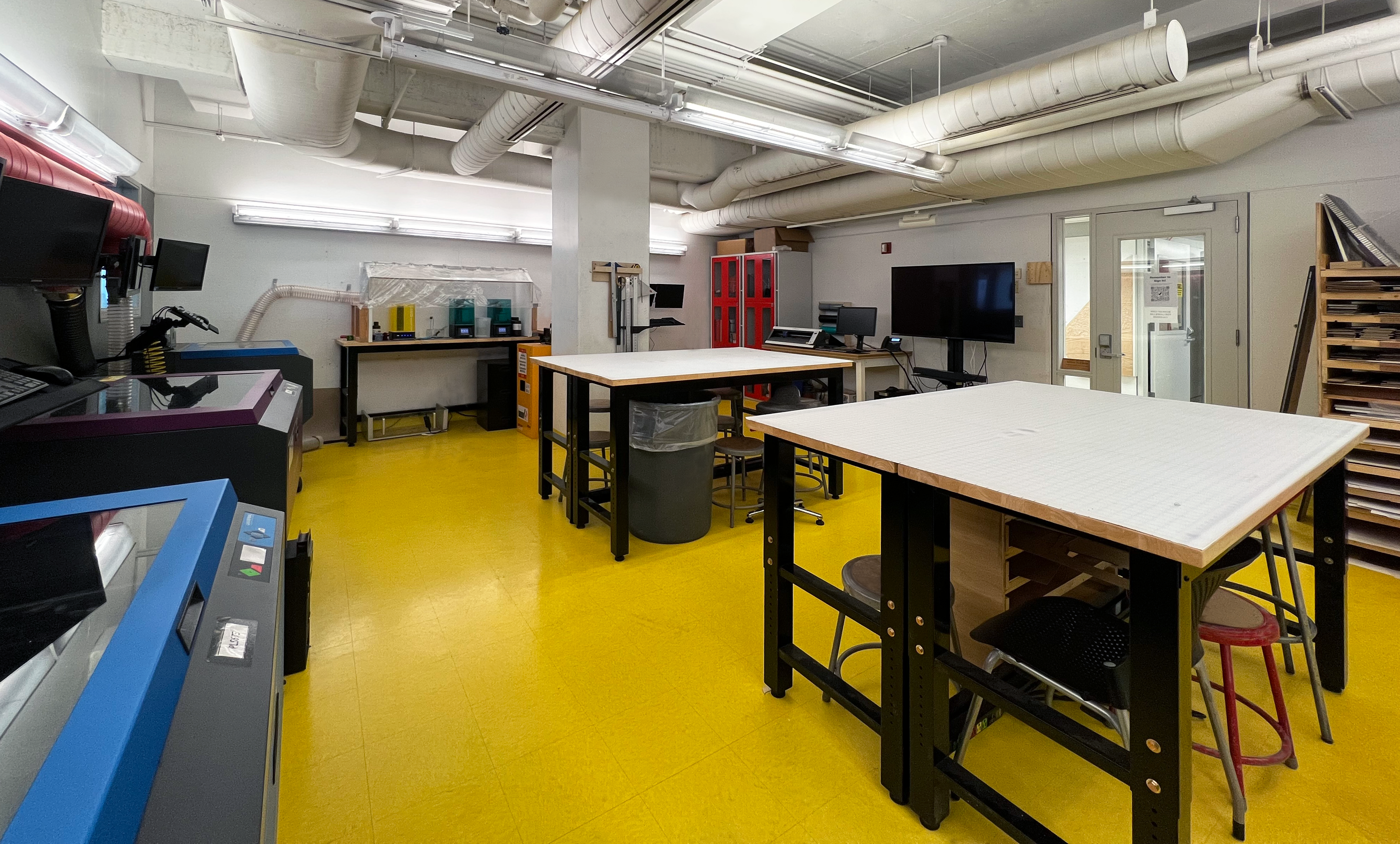 Photo of Laser Lab at HCAD including Laser Cutters, 3D Printers, Vinyl Cutters and work tables.